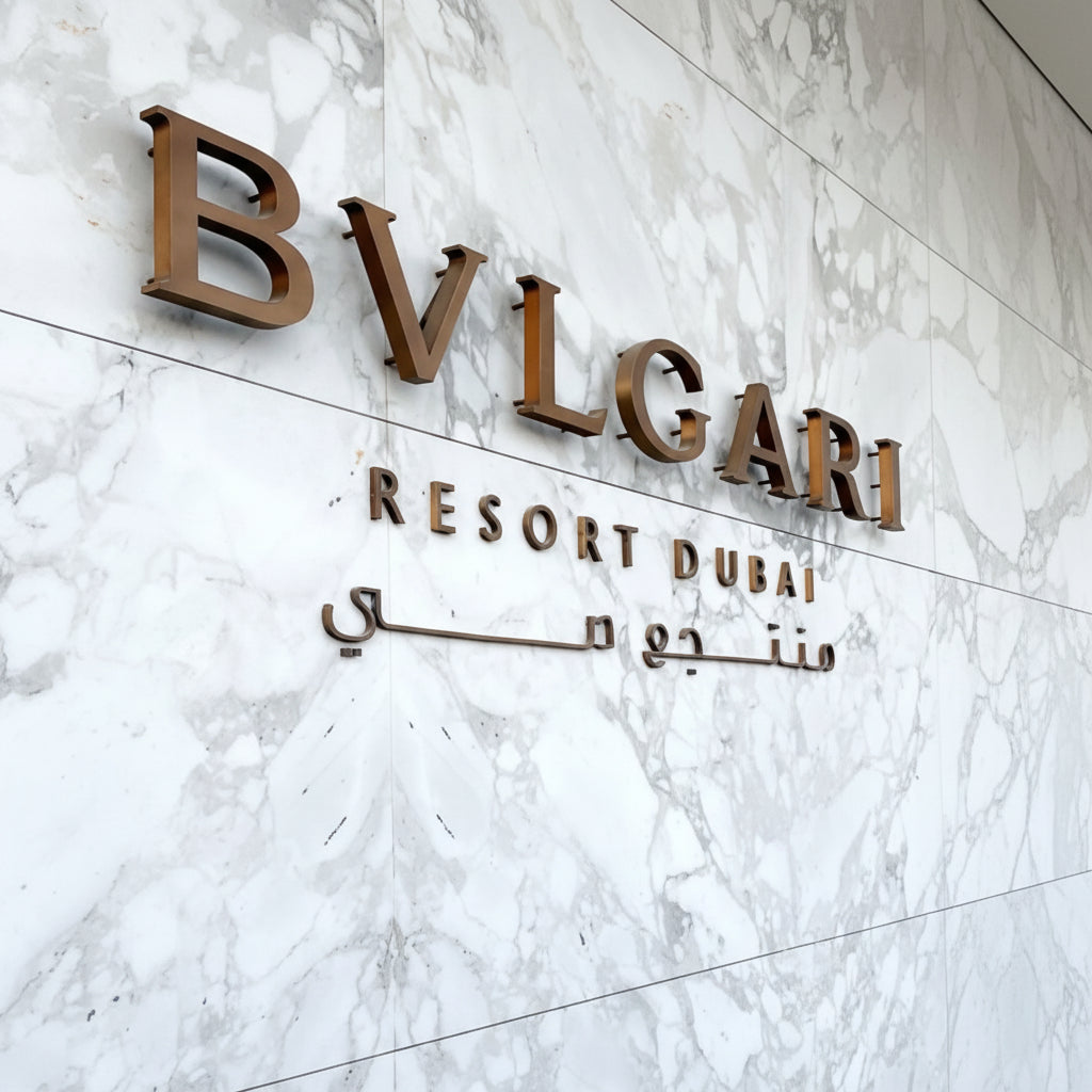 Premium bronze acrylic letter sign mounted on a marble wall, creating an elegant hotel reception and luxury business branding display.