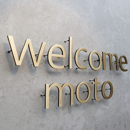 Premium custom 3D metal letter sign with standoff mounting on a textured wall, ideal for office receptions, corporate branding, hotels, and commercial interiors.