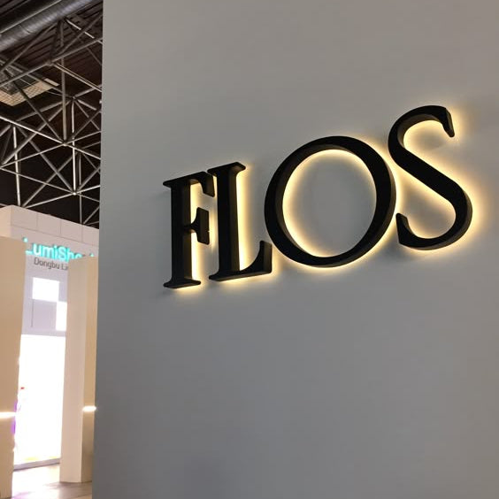 Black halo-lit acrylic letter sign mounted on a wall with warm LED backlighting, creating a premium and modern business branding display.