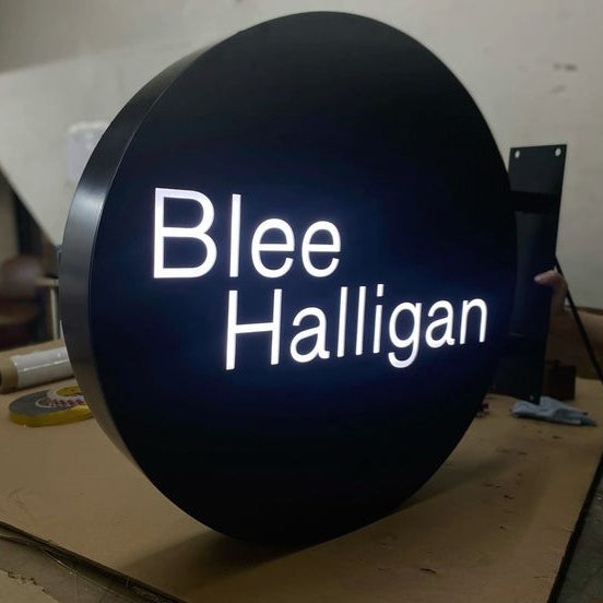 Custom circular business branding sign featuring bright LED logo display for office reception