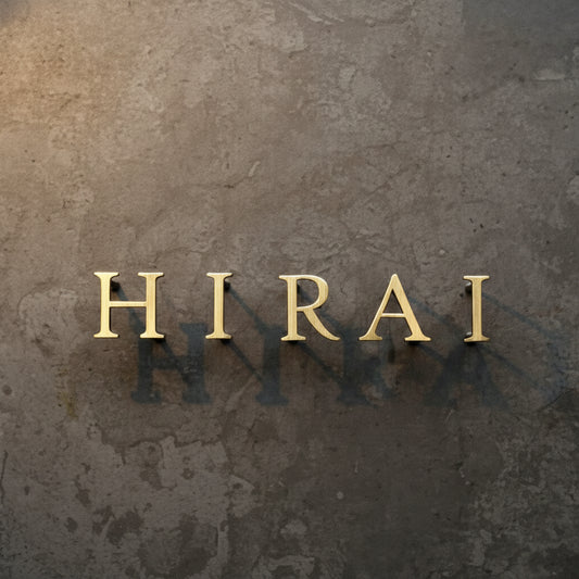 Brushed gold acrylic letter sign mounted with standoffs on a textured wall, creating an elegant and professional business branding display.