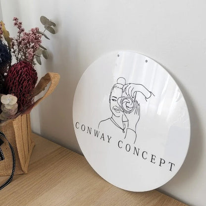 Modern circular business branding sign with glossy white finish and artistic logo design