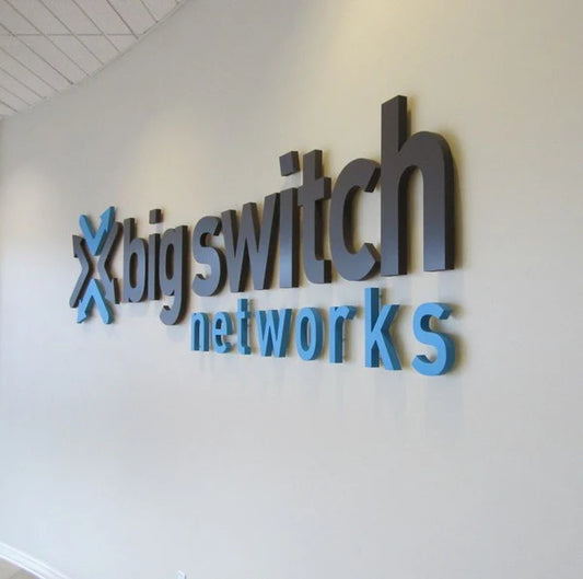 Modern office branding with black and blue acrylic business logo lettering.