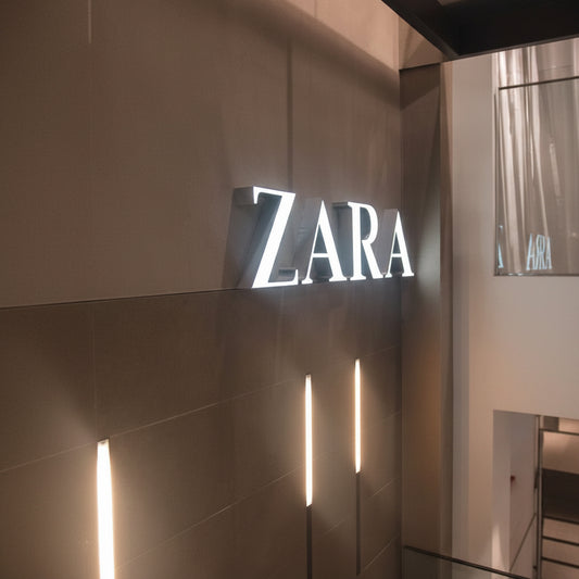 Custom LED acrylic letter sign with bright white illuminated letters mounted on a modern retail interior wall.