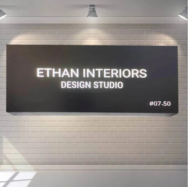 Modern illuminated office wall sign featuring 3D acrylic letters on a premium black backing panel.