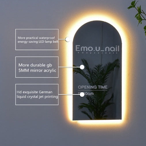 Custom arch-shaped acrylic mirror sign with warm halo LED backlighting, ideal for salons, studios, and modern business interiors.