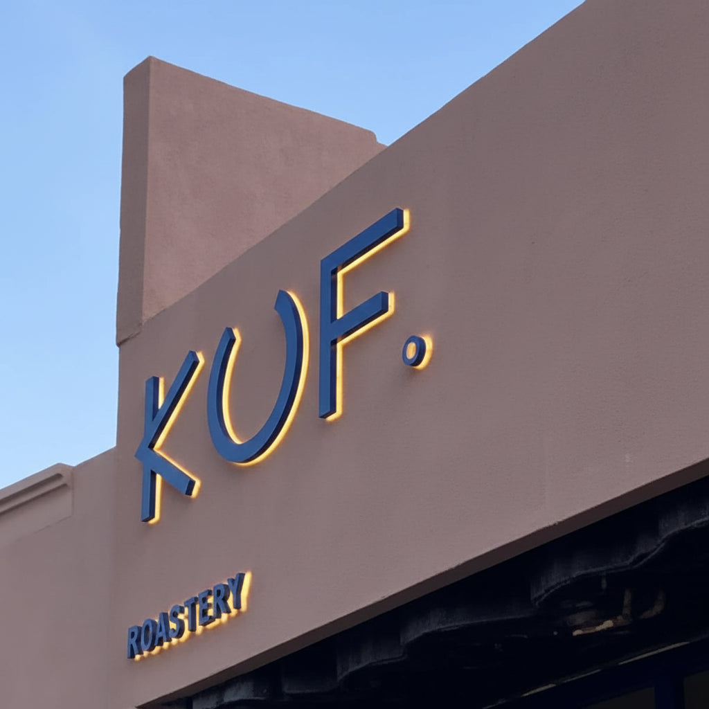Custom blue halo-lit channel letter sign mounted on a storefront exterior wall with warm LED backlighting for premium business branding.
