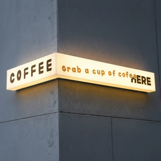 Modern wrap-around acrylic LED sign installed on a building corner for retail branding.