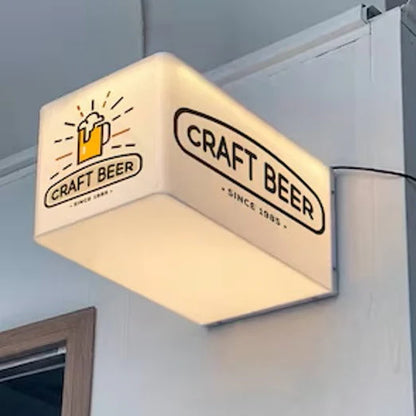 Wall-mounted acrylic cube light box displaying custom business logo for a café or brewery.