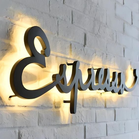 Custom halo-lit acrylic letter sign mounted on a white brick wall with warm LED backlighting for premium business branding.
