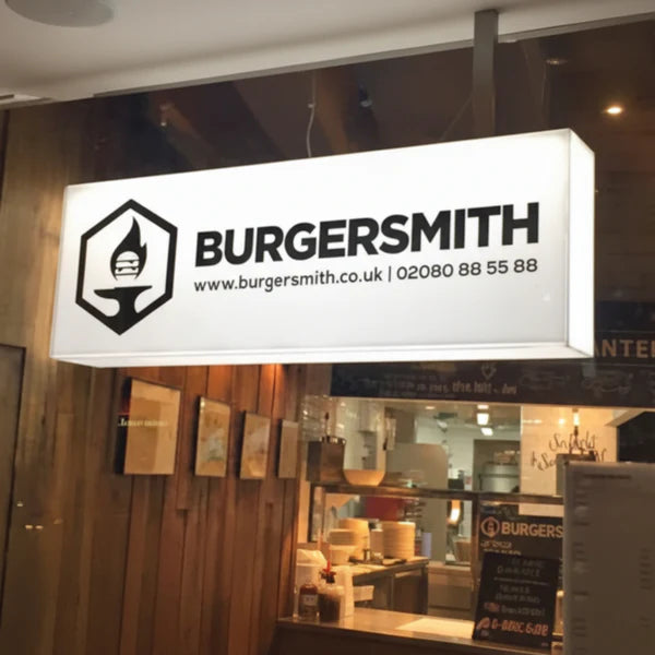 Illuminated rectangular hanging acrylic sign for a burger restaurant with custom logo and business name.