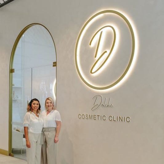 Custom illuminated LED acrylic letter wall sign installed in a modern cosmetic clinic reception area with elegant backlit branding.