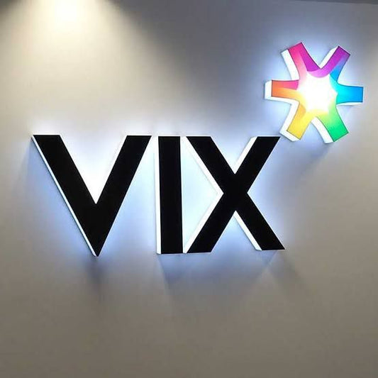 Custom illuminated LED logo sign featuring acrylic channel letters and a colorful backlit logo mounted on a modern office wall.