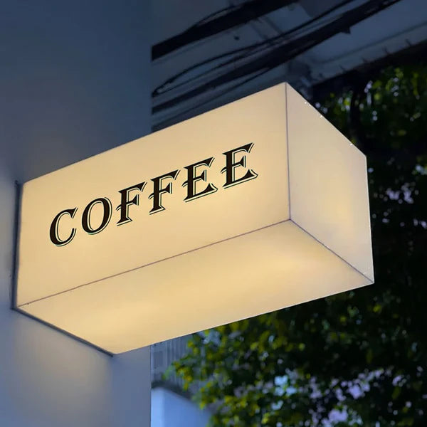 Modern wall-mounted acrylic LED sign for café storefronts with bright white illumination.