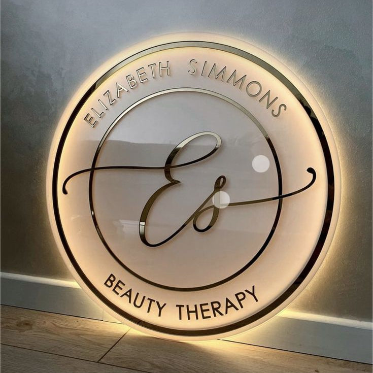 Illuminated circular beauty therapy business sign with warm LED backlighting