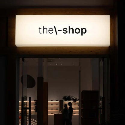 Modern rectangular business light box sign displaying custom branding above a commercial storefront.