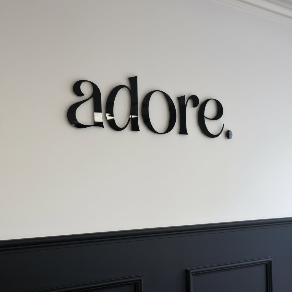 Gloss black acrylic letter sign mounted on a white wall, creating a sleek and professional business branding display.