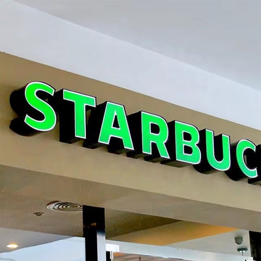 Green illuminated 3D LED channel letter storefront sign mounted on commercial facade