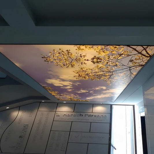 Custom illuminated stretch ceiling light panel featuring scenic tree and sky artwork