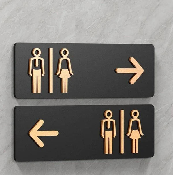 Custom washroom wayfinding neon sign with directional arrows for commercial interiors.