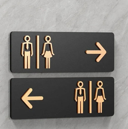 Custom washroom wayfinding neon sign with directional arrows for commercial interiors.