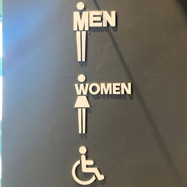Custom accessible restroom neon sign with male, female, and wheelchair symbols for public spaces.