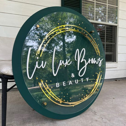 Elegant round beauty salon branding sign featuring layered acrylic lettering and emerald green frame