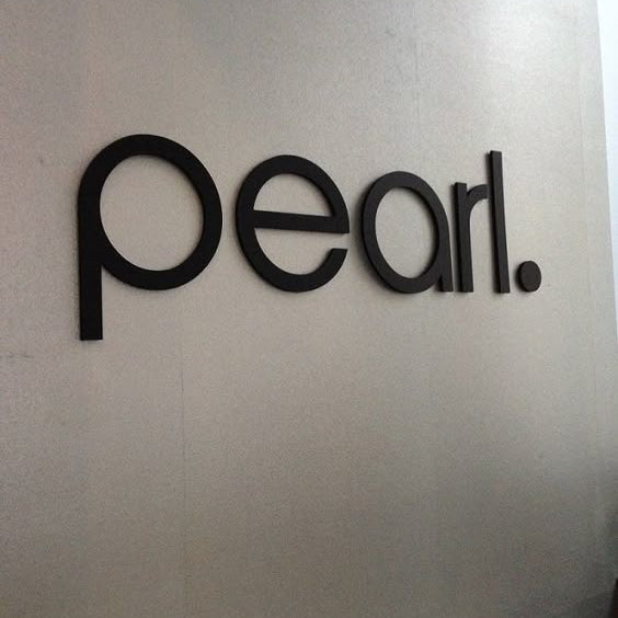 Modern black acrylic letter wall sign mounted on an office reception wall for professional business branding and interior signage.