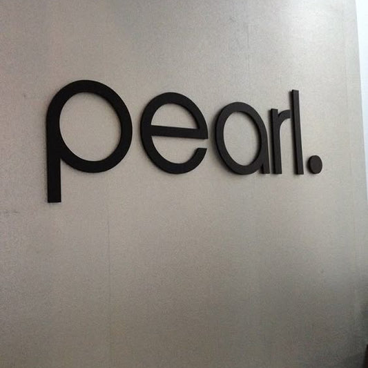 Modern black acrylic letter wall sign mounted on an office reception wall for professional business branding and interior signage.
