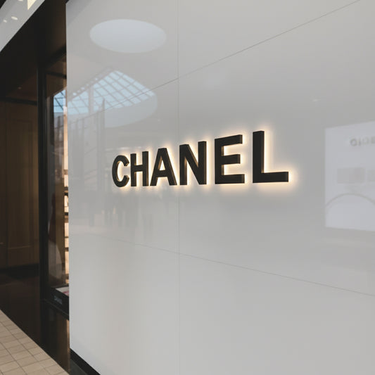 Modern custom LED backlit metal logo sign mounted on a gray wall, featuring halo-lit letters for premium business branding and interior décor.