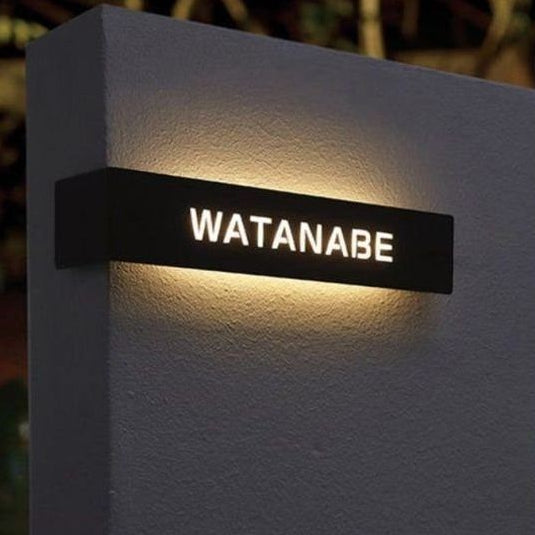 Modern custom LED house name plate with illuminated lettering mounted on an exterior wall, ideal for home entrance, villa, apartment, and office address signage.