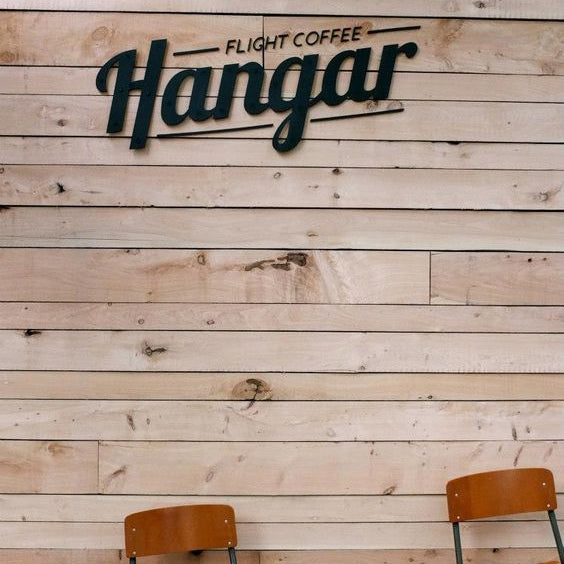 Modern custom coffee shop metal logo sign mounted on a wooden wall, ideal for cafés, restaurants, coffee bars, and commercial business interiors.