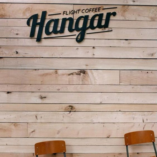Modern custom coffee shop metal logo sign mounted on a wooden wall, ideal for cafés, restaurants, coffee bars, and commercial business interiors.