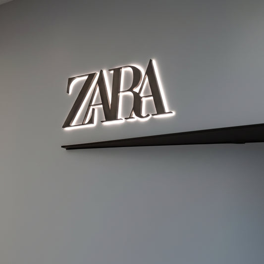 Modern illuminated Zara logo wall art featuring a luxury fashion-inspired minimalist design on a gray wall.