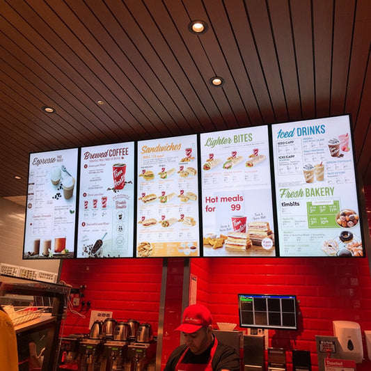 Commercial LED menu display installed above a fast-food service counter with customizable digital screens