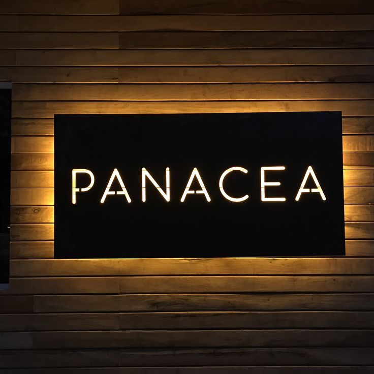 Modern backlit business branding sign featuring glowing letters on black panel