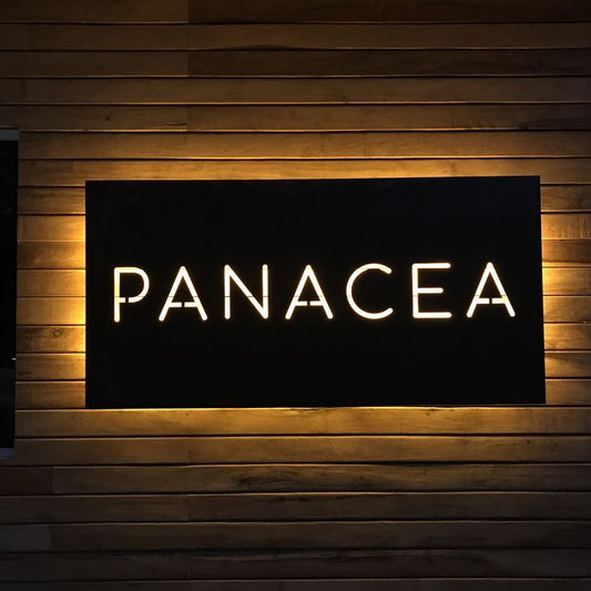 Modern backlit business branding sign featuring glowing letters on black panel