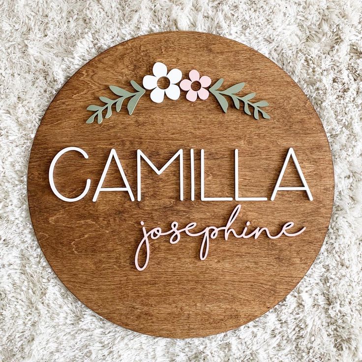 Round nursery name plaque featuring custom baby name on natural wood background