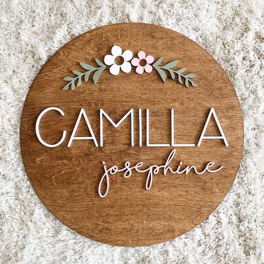 Round nursery name plaque featuring custom baby name on natural wood background