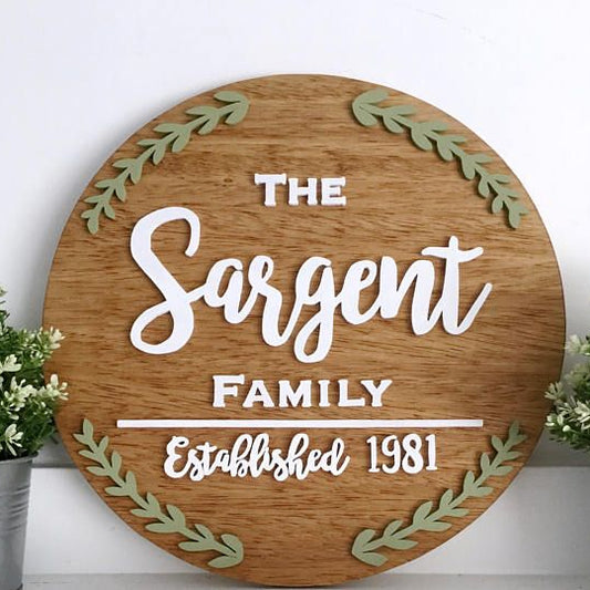 Round farmhouse-style family plaque featuring botanical accents and custom surname design