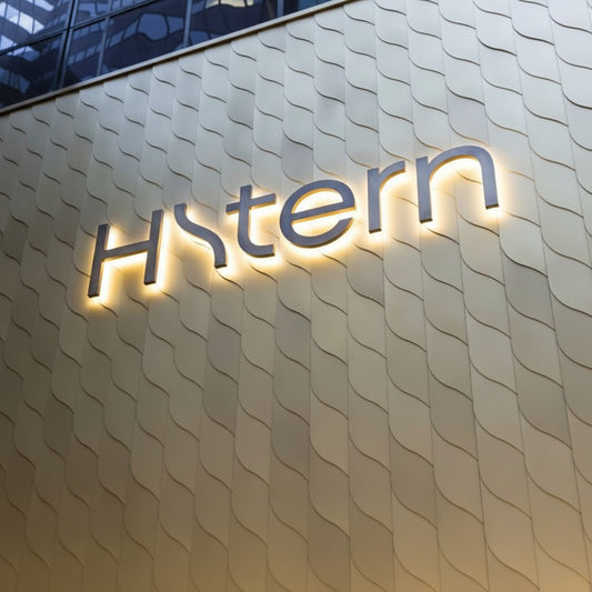 Premium custom halo-lit channel letter sign with warm LED backlighting installed on an exterior building wall for modern business branding and storefront signage.
